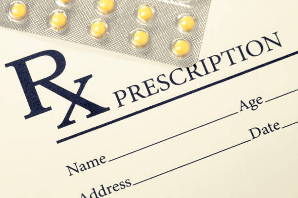 Medical drug prescription and pills over it - studio shot. Filtered image: cross processed vintage effect.