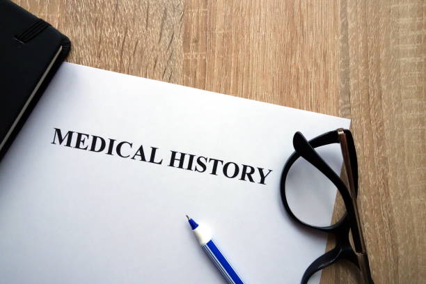 Medical history document, pen and glasses on desk